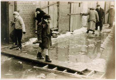 Un enfant tenant un bol de soupe traverse une rue inondée sur une planche de bois dans le ghetto de Łódź (Pologne), vers 1940-1944.
United States Holocaust Memorial Museum, avec l’aimable autorisation d’Arie Ben Menachem.